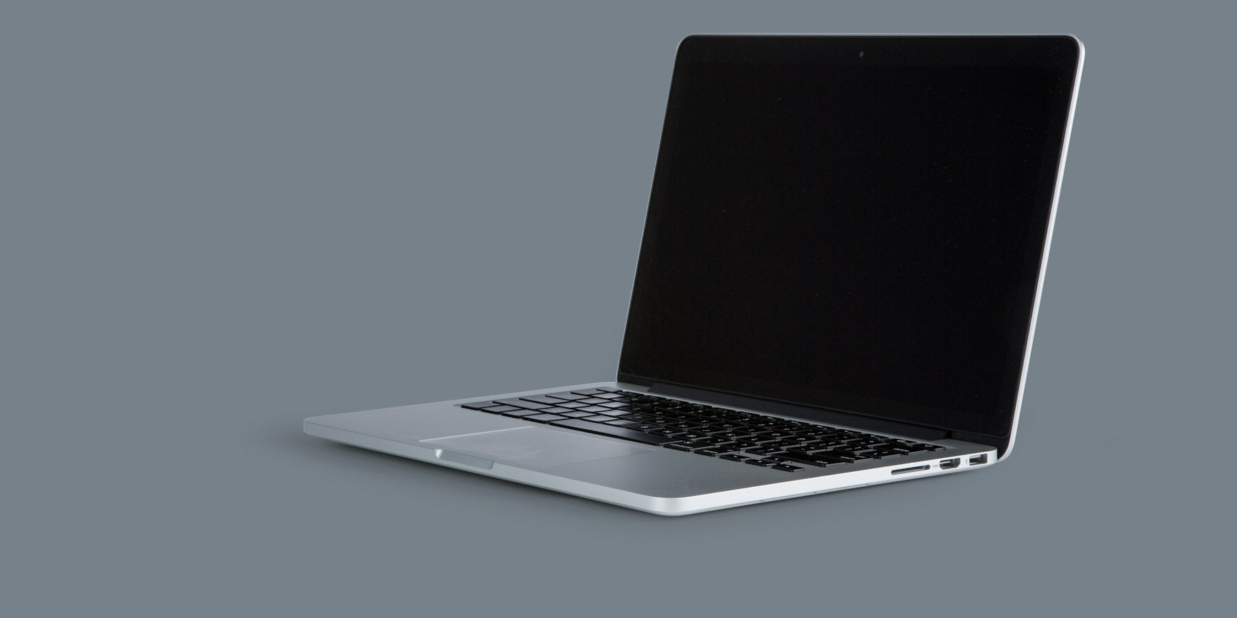 Laptop abierta sobre fondo gris (imagen ilustrativa)