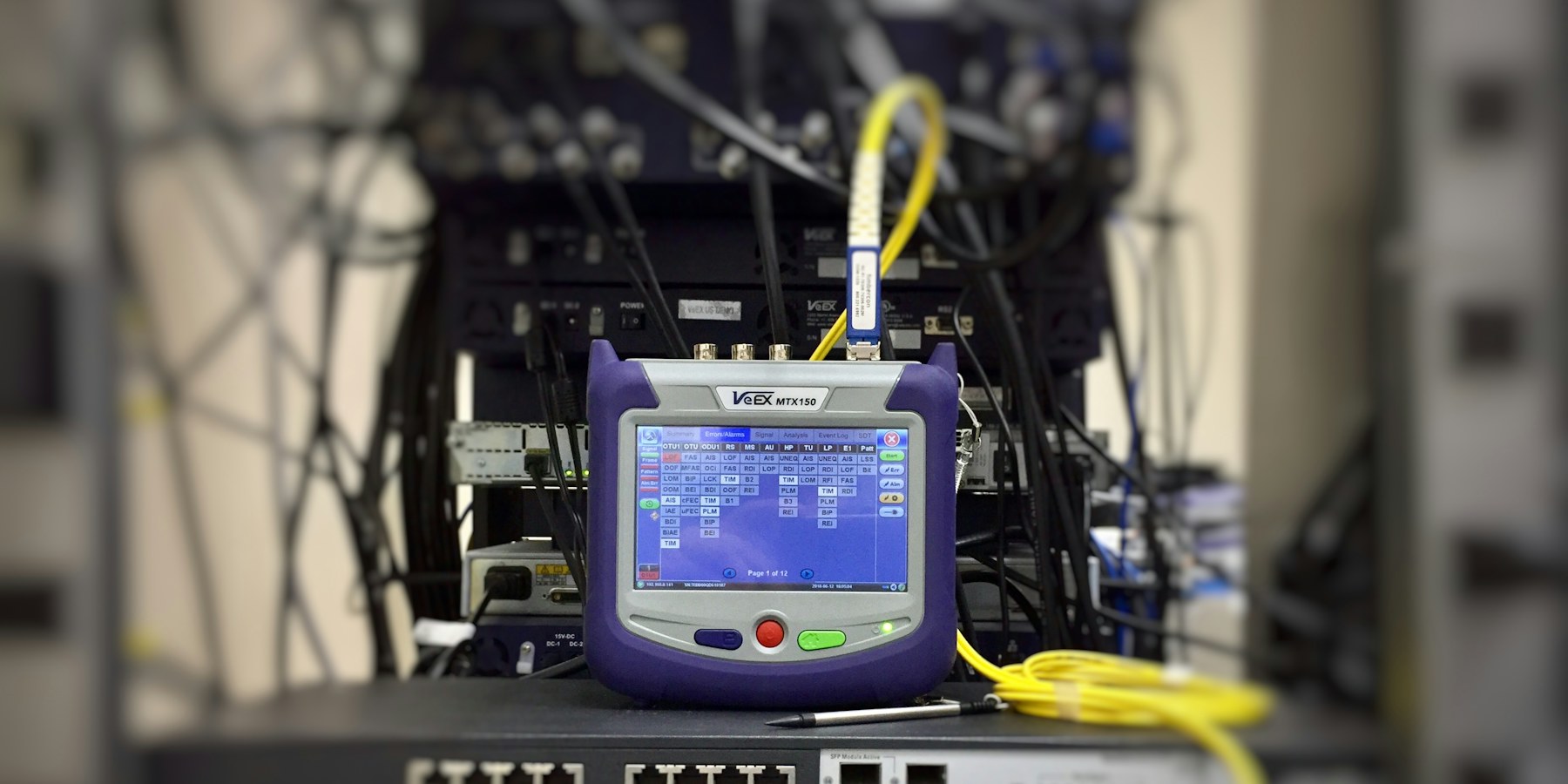 Equipo de prueba de fibra óptica conectado en un rack (imagen ilustrativa)